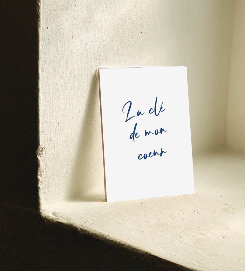 May include: A white card with blue cursive text that reads 'La clé de mon coeur'.