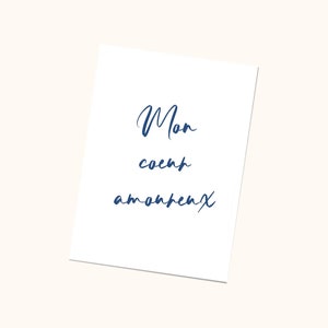 May include: A white card with the words 'Mon coeur appartient' written in blue cursive script.