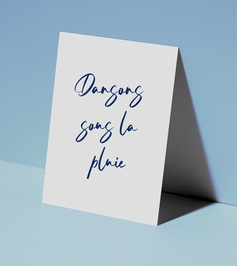 May include: A white card with the words 'Dansong song la pluie' written in blue cursive script.