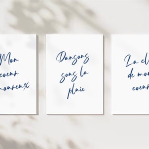 May include: Three white cards with blue text. The first card says 'Mon coeur amoureux'. The second card says 'Dansons sans la pluie'. The third card says 'La clé de mon coeur'. 