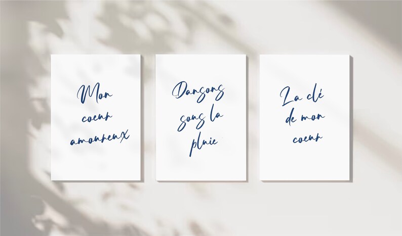 May include: Three white cards with blue text. The first card says 'Mon coeur amoureux'. The second card says 'Dansons sans la pluie'. The third card says 'La clé de mon coeur'. 
