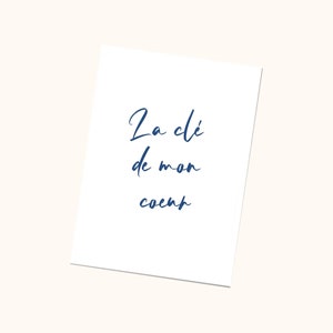 May include: A white card with blue cursive text that reads 'La clé de mon coeur'.