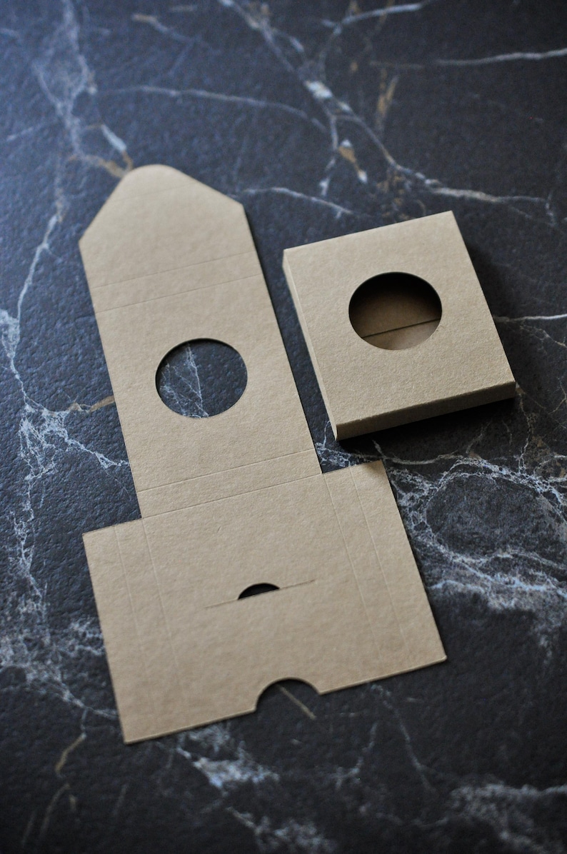 May include: A set of three brown cardboard boxes with round cutouts. The boxes are designed to be assembled into a tower shape.