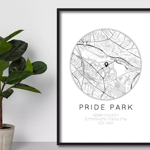 Może przedstawiać: Czarno-biały wydruk mapy Pride Park, Derby County, Anglia. Mapa znajduje się w okręgu z czarną szpilką oznaczającą lokalizację. Tekst pod mapą brzmi "Pride Park, Derby County, 52°54'54.0"N 1°26'50.2"W, Est. 1997."