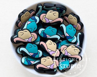 May include: A bowl filled with colorful silicone cowboy hat charms. The hats are in shades of blue, pink, and brown. The charms have a hole in the top for attaching to a necklace or bracelet.