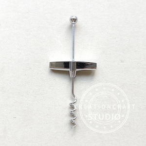 May include: A silver corkscrew with a T-shaped handle and a spiral corkscrew. The corkscrew has a ball on the top of the handle.