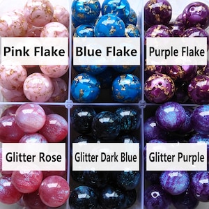 May include: Assortment of colourful glass beads with different finishes. Pink, blue, and purple beads with gold flakes. Glitter rose, glitter dark blue, and glitter purple beads.