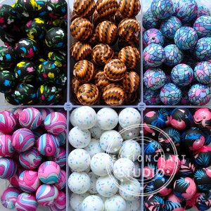 May include: Assortment of colourful silicone beads in various patterns, including swirls, confetti, and floral designs. The beads are arranged in six rows, with each row containing a different pattern.