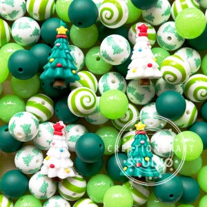 May include: A collection of green, white, and red Christmas tree-themed silicone beads. The beads feature various designs, including striped, swirl, and Christmas tree patterns. The beads are perfect for making necklaces, bracelets, or other crafts.