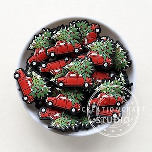 May include: A bowl filled with red miniature cars with Christmas trees on top. The cars are decorated with green trees and colorful lights.