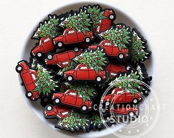May include: A bowl filled with red miniature cars with Christmas trees on top. The cars are decorated with green trees and colorful lights.