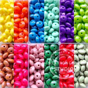 Peut inclure: Assortiment de 10 couleurs de perles en bois dans une boîte de rangement en plastique transparent. Les perles sont rondes et plates avec un trou au centre. Les couleurs sont jaune, orange, bleu, vert, violet, marron, rose, rouge et beige.