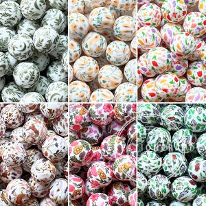 Puede incluir: Una colección de cuentas redondas con varios patrones impresos que incluyen motivos botánicos verdes, diseños florales naranjas, tulipanes coloridos, flores silvestres, flores rosas y amarillas vibrantes e ilustraciones de rosas en blanco y negro.