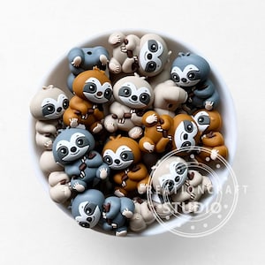 May include: A collection of miniature sloth figurines in a white bowl. The sloths are in various shades of brown, gray, and beige, with black and white facial details. The figurines are arranged closely together, creating a playful and whimsical scene.