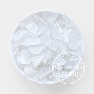 Può includere: Una ciotola bianca piena di numerosi componenti in plastica trasparenti a forma di semicerchio. Ogni pezzo ha un piccolo foro. I componenti traslucidi sono probabilmente piccoli, forse per l'artigianato o la gioielleria.