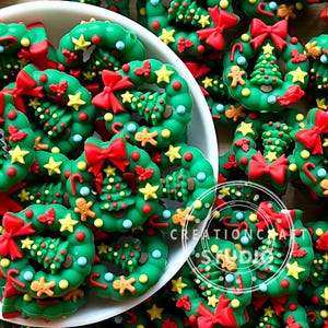 Peut inclure: Gros plan sur des décorations de Noël en forme de couronne. Les couronnes vertes sont ornées de nœuds rouges, d'étoiles jaunes et de petits bonhommes en pain d'épices. Les décorations sont dans un bol blanc et sur une surface en bois.
