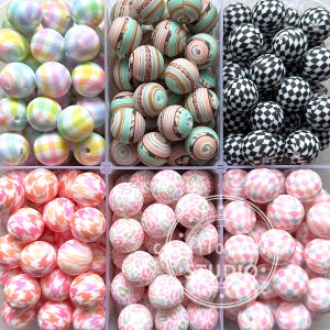 May include: A set of six containers filled with colourful silicone beads. The beads are in various patterns, including gingham, leopard print, and checkered.