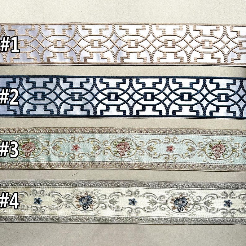 May include: Four samples of decorative trim with different patterns. The first trim is white with a gold geometric pattern. The second trim is white with a black geometric pattern. The third trim is light blue with a floral pattern. The fourth trim is cream with a floral pattern.