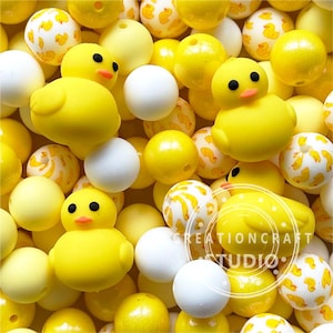 Peut inclure: Un ensemble de perles en silicone jaunes et blanches avec un motif de canard. Les perles sont parfaites pour faire un anneau de dentition pour bébé ou un jouet sensoriel.