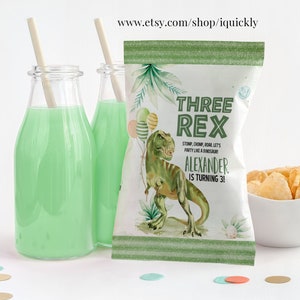 Op de afbeelding: Groene en witte chipzak met een dinosaurus-illustratie en de tekst "Three Rex Stomp, Chomp, Roar Let's Party Like A Dinosaur! Alexander Is Turning 3!"