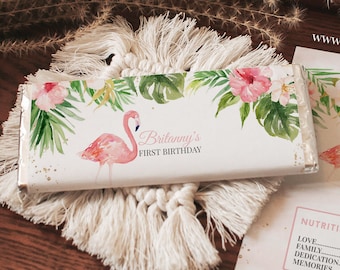 May include: Pink flamingo and tropical floral design on a white chocolate bar wrapper. The wrapper says "Britanny's First Birthday".