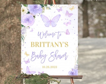 May include: Purple and gold baby shower welcome sign featuring butterflies and flowers. The sign reads "Welcome to Brittany's Baby Shower 10.25.2023".