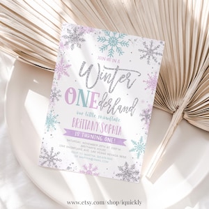 May include: A white invitation with a silver glitter design for a Winter Wonderland themed first birthday party. The invitation features snowflakes, the text "Join us in a Winter Wonderland", and the name "Brittany Sophia".