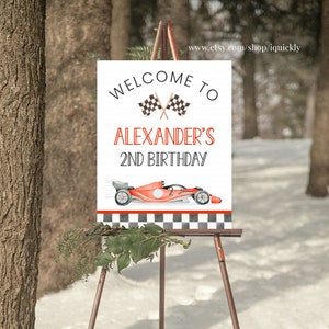 May include: Welcome to Alexander's 2nd Birthday sign with a red race car and checkered flag design.