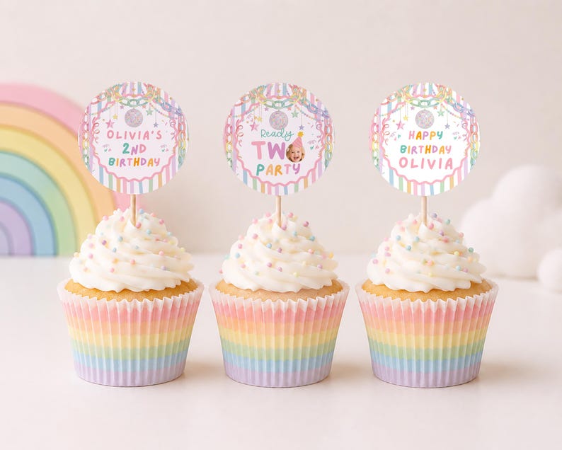 May include: Three cupcakes in rainbow-striped paper liners topped with white frosting and colorful sprinkles. Each cupcake features a round paper topper with pastel stripes, stars, and text reading Olivia's 2nd Birthday, Ready Two Party, and Happy Birthday Olivia.