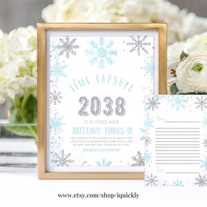 Peut inclure: Une capsule temporelle imprimable pour une fête d'anniversaire. La carte blanche présente un motif de flocons de neige bleus et argentés et le texte "Time Capsule 2038 To Be Opened When Brittany Turns 18". La carte contient des instructions pour écrire une note sur les rêves et les aspirations de la fille d'anniversaire pour l'avenir. Une deuxième carte avec des lignes pour écrire est également incluse.