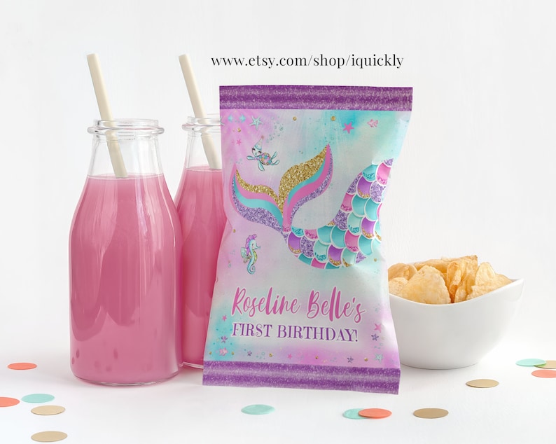 May include: Purple and blue mermaid tail party favour bags with gold glitter accents. The bags have a mermaid tail design with a seahorse and a starfish. The text on the bag reads "Roseline Belle's First Birthday!"