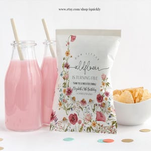 以下が含まれることがあります： 花柄の白いチップス袋に「Our Little Wildflower is turning five. Thank you so much for coming. Elyth's 5th Birthday. October 27, 2024」の文字が書かれています。