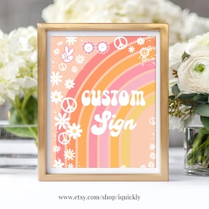 May include: A gold framed sign with a rainbow background and white daisies. The text "CUSTOM SIGN" is in white with a retro font.