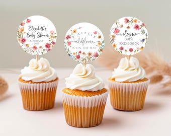 Könnte beinhalten: Drei Cupcake-Topper mit Blumenmustern und Text. Der erste Topper sagt "Elizabeth's Baby Shower October 25th 2024". Der zweite Topper sagt "A Little Wildflower Is On The Way". Der dritte Topper sagt "Welcome Baby Anderson".