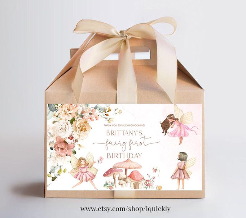 May include: A brown favor box with a pink and white floral design and a label that says "Thank you so much for coming! Brittany's Fairy First Birthday". The box is tied with a beige ribbon.