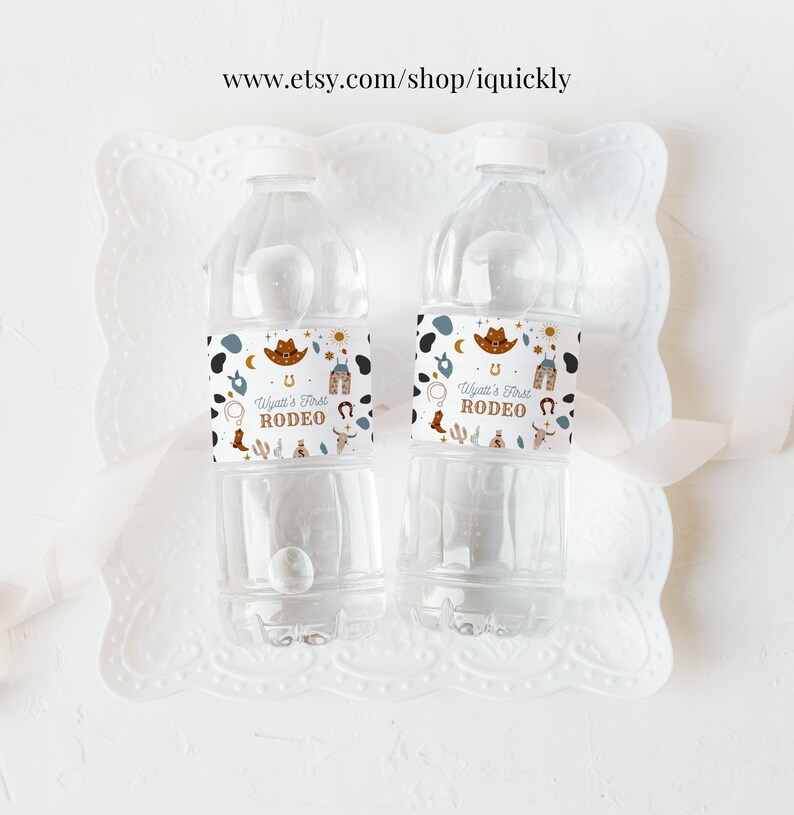 May include: Two clear plastic water bottles with white labels. The labels have a western theme with a cowboy hat, horseshoe, and the text "Wyatt's First Rodeo".