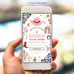 Könnte beinhalten: Eine digitale Einladung in Rosa und Gold für eine zweite Geburtstagsfeier für ein Mädchen mit einem Rodeo-Thema. Die Einladung zeigt einen rosafarbenen Cowboyhut, ein Paar braune und weiße Cowboystiefel, ein Hufeisen, ein Bandana und einen Kaktus. Der Text auf der Einladung lautet: "Das ist nicht mein erstes Rodeo, es ist mein zweites. Sattelt eure Pferde, es ist Zeit, den zweiten Geburtstag von Lillian zu feiern."