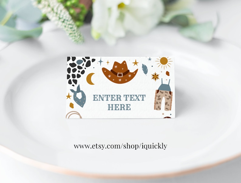 May include: A white card with a cowboy hat, stars, a sun, and a pair of overalls printed on it. The text "ENTER TEXT HERE" is printed in black on the card. The card is on a white plate.