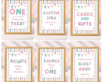 Op de afbeelding: Zes goudomlijste borden met witte achtergronden, pastelkleurige gestreepte randen en kleurrijke vlaggetjesafbeeldingen. De tekst luidt: ONE is sweet PLEASE TAKE A TREAT, CUSTOM SIGN, CARDS AND GIFTS, DRINKS PLEASE HELP YOURSELF, FAVORS PLEASE TAKE ONE en PLEASE SIGN OUR GUEST BOOK THANK YOU.