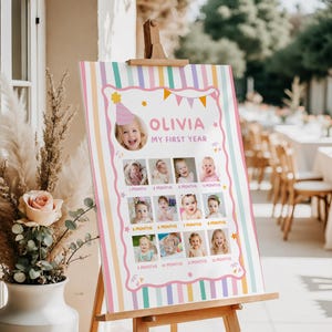 Pu&ograve; includere: Un cartello rettangolare verticale con sfondo a righe pastello, il nome OLIVIA e il testo MY FIRST YEAR. Mostra dodici fotografie quadrate disposte in una griglia, ciascuna etichettata con un mese da 1 MONTH a 12 MONTHS.