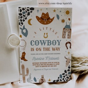 May include: A baby shower invitation with a cowboy theme. The invitation features a brown cowboy hat, a blue bandana, a pair of blue jeans, a horseshoe, and a cactus. The text on the invitation reads "A Little Cowboy is on the Way".
