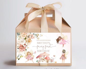 Op de afbeelding: Een bruine traktatiebox met een roze en wit bloemenontwerp en een label met de tekst "Bedankt voor je komst! Brittany's Fairy First Birthday". De doos is vastgebonden met een beige lint.