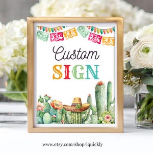 May include: A printable sign with a gold frame and a white background. The sign says "Custom Sign" in colorful letters. The sign is decorated with a string of colorful paper flags and a border of cacti and succulents.