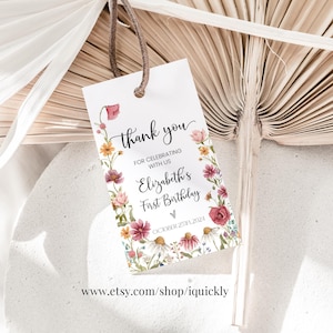 Op de afbeelding: Een wit bedankkaartje met een bloemige rand. De tekst luidt "Bedankt voor het vieren met ons van Elizabeths eerste verjaardag".