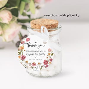 Op de afbeelding: Ronde bedankkaart met bloemenmotief. De kaart zegt "Bedankt dat je met ons Elizabeths eerste verjaardag viert".