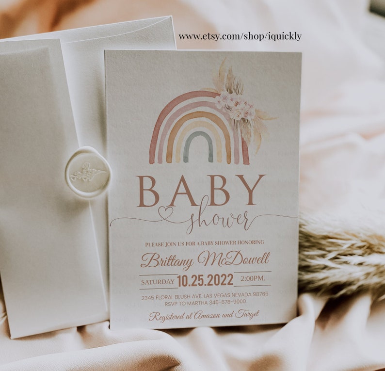May include: A baby shower invitation with a watercolor rainbow design. The invitation features the text "BABY shower" and includes details for the event, including the date, time, and location. The invitation also includes the text "Registered at Amazon and Target".