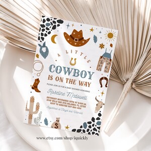 May include: A white baby shower invitation with a cowboy theme. The invitation features a brown cowboy hat, a blue bandana, a pair of brown cowboy boots, a cactus, a horseshoe, and a gold star. The text on the invitation reads "A Little Cowboy is on the Way".