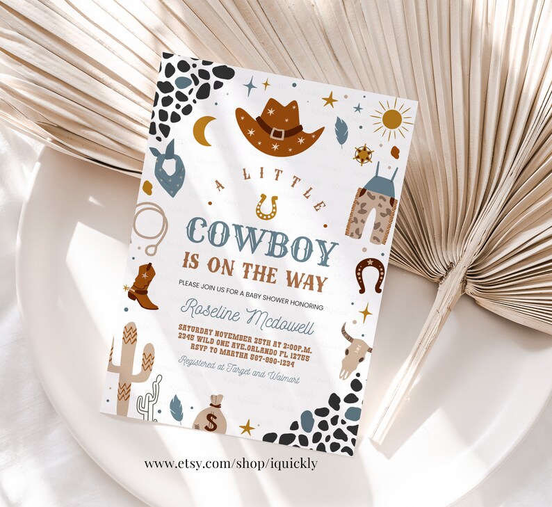 May include: A white baby shower invitation with a cowboy theme. The invitation features a brown cowboy hat, a blue bandana, a pair of brown cowboy boots, a cactus, a horseshoe, and a gold star. The text on the invitation reads "A Little Cowboy is on the Way".