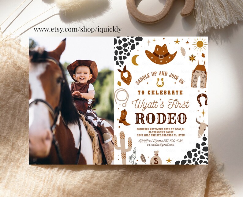 May include: A white invitation with brown and gold accents for a child's first rodeo. The invitation features a cowboy hat, boots, a horseshoe, and a cactus. The text on the invitation reads "Saddle Up and Join Us to Celebrate Wyatt's First Rodeo".
