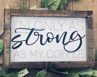 May include: A wooden sign with a white background and black lettering that reads "Only as strong as my coffee".